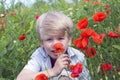 Nice blond boy with a red poppy in his hand. Royalty Free Stock Photo