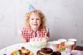 Nice blond child holding forks and going to taste dessert