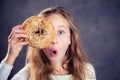 Blond girl looking through a big bagel Royalty Free Stock Photo