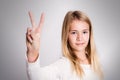 Nice blond girl showing victory sign Royalty Free Stock Photo