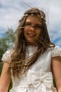 A nice blond girl smiles as the wind moves her hair, the day of her holy communion Royalty Free Stock Photo