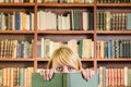 Nice blonde girl hiding behind a book