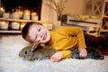 nice blue eyed boy playing wmiling with the rabbits on the cozy room`s carpeted floor Royalty Free Stock Photo