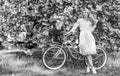 Nice bouquet. lady walk in park. pink cherry tree blossom. girl carry flower in retro bicycle. spring beautiful woman in Royalty Free Stock Photo