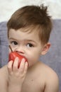 The nice boy eats a red pear Royalty Free Stock Photo