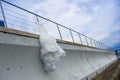 Nice bridal dress is hanging on the pier fencing.