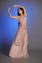 Brunette girl in oriental dress on a blue background in the studio Royalty Free Stock Photo