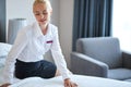 Nice chambermaid prepares a bed for guests