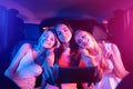 Nice and cheerful girl are sitting in car together. Blonde girls are resting on their friend`s shoulders. Brunette is Royalty Free Stock Photo