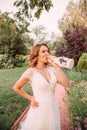 Nice and cheerful, happy young blonde girl in a white elegant wedding long dress drinking champagne from a beautifully Royalty Free Stock Photo