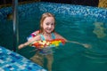 Nice child swiming in blue small pool. Girl have fun in water indoors Royalty Free Stock Photo