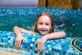 Nice child swiming in blue small pool. Girl have fun in water indoors Royalty Free Stock Photo