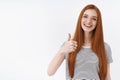 Nice choice support. Charming redhead cute european girl show thumb up approval smiling delighted like great effort