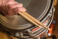 Nice closeup detailed view of human person hands holding used drum sticks on old dusty snare drum background