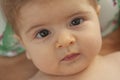 Nice closeup portrait of cute blond baby with brown eyes looking direct into the camera