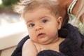 Nice closeup portrait of cute blond baby with brown eyes in towel looking direct into the camera