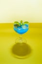 Nice cocktail with ice and blueberries. Neon blue drink with vibrant colors. Party concept background