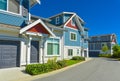 Row of new residential townhouse with entrance and garage doors on sunny day