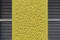 Nice concrete background toned yellow against closed gray shutters - Wall surface texture - Grunge bright illuminating color