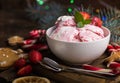 Ice cream served in a glass bowl. Displayed with candy canes on wooden rustic table. Sparkling Christmas tree lights background