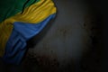 nice dark image of Gabon flag with big folds on rusty metal with free space for content - any feast flag 3d illustration