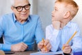 Nice delighted boy studying together with his grandfather Royalty Free Stock Photo