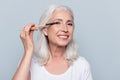 Nice, delighted, caucasian, attractive, aged woman applying eyes Royalty Free Stock Photo