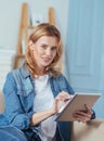 Pretty pleasant woman using her modern device and smiling