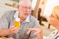 Nice Doctor or Nurse Explaining Prescription Medicine to Attentive Senior Man Royalty Free Stock Photo