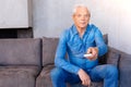 Nice elderly man holding a remote control Royalty Free Stock Photo