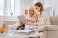 Nice elderly woman learning how to use a laptop