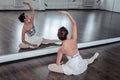 Nice elegant ballet dancer sitting in front of the mirror