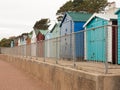a nice even row of beach huts with fence in front down in dovercourt harwich Royalty Free Stock Photo