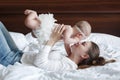 Young mother and her baby daughter playing togerher on the bed at home Royalty Free Stock Photo