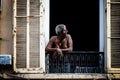 Nice, France - August 6, 2011: a shirtless old black man looks out the window at Nice in Provence, France Royalty Free Stock Photo