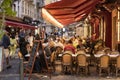 Guests in a restaurant with tables and chairs on the sidewalk at a street in Nice, France, in the dusk Royalty Free Stock Photo