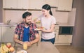 Nice giel stands besides guy and give him plate with omlet and cherry tomatoes. He looks at it and smile. Guy is hungry