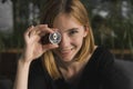 A nice girl is attaching a gold and silver ethereum coin to her eye. Bitcoins, crypto currency, electronic money. Woman