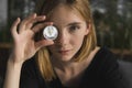 A nice girl is attaching a gold and silver ethereum coin to her eye. Bitcoins, crypto currency, electronic money. Woman