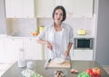 Nice girl is blending together milk with eggs in glass bowl. She is looking on camera and smiling. There is a lot of Royalty Free Stock Photo