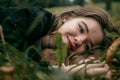 The girl lies on the ground in the leaves and looks at the camera Royalty Free Stock Photo