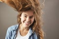Nice girl with long brown flowing hair smiles on a gray background Royalty Free Stock Photo