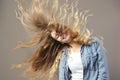 Nice girl with long brown flowing hair smiles on a gray background Royalty Free Stock Photo