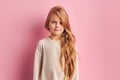 Nice girl with long golden hair wearing white blouse isolated on pink background Royalty Free Stock Photo