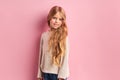 Nice girl with long golden hair wearing white blouse isolated on pink background Royalty Free Stock Photo