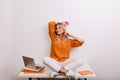 Nice girl in oversize knitted shirt posing with smile in her cozy office. Indoor portrait of fashionable business-woman