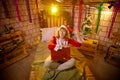 Nice girl in a red dress and hat of Santa with big red gift box in room decorated for Christmas. Woman in beautirul Royalty Free Stock Photo