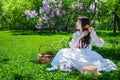 Nice girl sits on a lawn in a park and combes her long hair Royalty Free Stock Photo