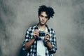 nice guy in a plaid shirt and a t-shirt with a camera in his hand model hobby studio