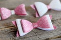 Nice hair bows accessories made of light pink and white felt with sequins. Hair bows for girls on an old wooden table. Closeup Royalty Free Stock Photo